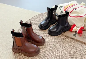 Gedetailleerde weergave van zwarte en bruine Chelsea boots met plateauzool