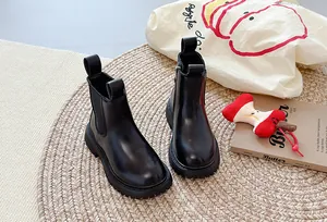 Trendy zwarte platform Chelsea boots op een geweven mat met gezellige lifestyle rekwisieten