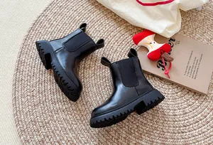 Detailopname van zwarte platform Chelsea boots met dikke profielzool op een mat