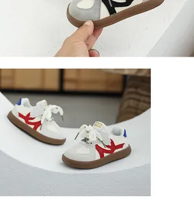 Stylish toddler German trainer sneakers with soft brown soles and red accents.