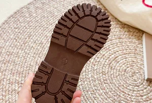 Gedetailleerde macroweergave van de antislip dikke rubberen zool van een bruine Chelsea boot