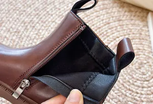 Detail van de ritssluiting en voering van bruine leren laarzen met platformzool
