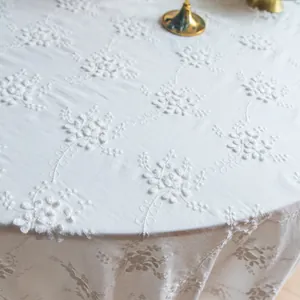 Gros plan d'une nappe en dentelle vintage française blanche avec broderie florale élégante