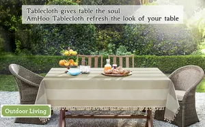 Vue détaillée d'une nappe en lin rayée avec des glands décoratifs dans un jardin extérieur