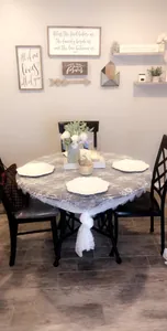 Detailed view of an elegant white lace tablecloth on a round dining table in a cozy home setting