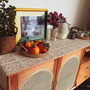 Vintage hollow lace crochet table runner displayed on a rustic wooden sideboard decor