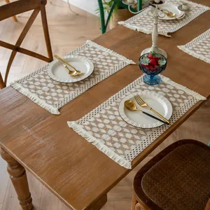 Bohemian farmhouse style woven cotton linen placemats with tassels on a wooden dining table
