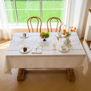 Elegant cream tablecloth with floral vine embroidery and decorative fringe edges