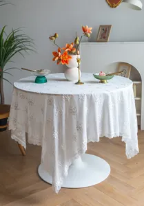 Gros plan de la broderie florale complexe sur une luxueuse nappe française en dentelle blanche