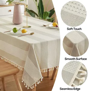 Vue macro détaillée montrant la texture douce et les bords à pompons de la nappe rayée.