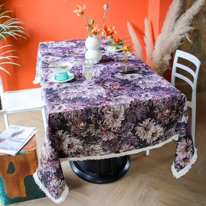 Vintage purple floral woven tablecloth with decorative white fringe on a dining table