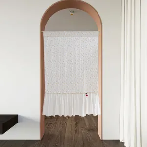 White floral cotton door curtain with elegant ruffles hanging in a modern arched doorway