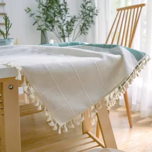 Nahaufnahme einer karierten Leinentischdecke mit Quastenrand in einem hellen Esszimmer