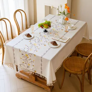 Detailed view of a premium cream embroidered floral tablecloth with elegant tassel edges