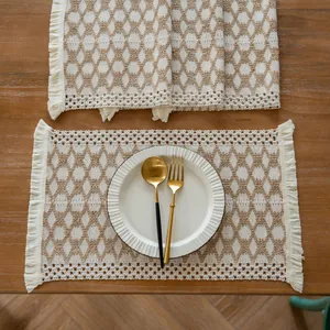 Top view of farmhouse woven placemat with tassels and fringe on a rustic wooden table