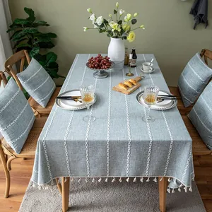 Detailed lifestyle view of a gray-blue tablecloth with 3D stitching and tassel trim