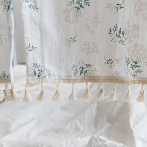 Close-up of floral print cotton door curtain with elegant cream tassel fringe detail.