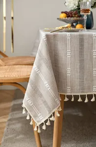 Close-up detail of retro rural cotton linen tablecloth with white embroidery and tassels