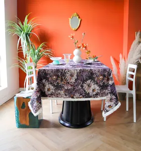 Detailed view of purple floral yarn-dyed tablecloth with tassel fringe in a room.