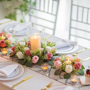 Artificial eucalyptus and rose candle ring wreath set on a beautifully decorated dining table