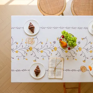 High-angle view of elegant embroidered floral pattern on linen-style tablecloth