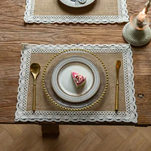 Rustic farmhouse jute placemat featuring delicate white lace trim on a vintage wooden dining table