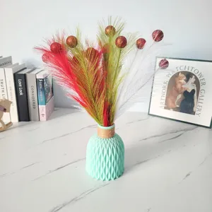 Detailansicht bunter Weihnachtsfederzweige mit glitzernden roten Schaumkugeln.