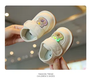 Dettaglio di scarpe da camminata LED color crema per neonati con design a orsetto
