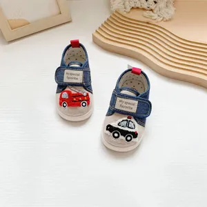 Detail shot of cartoon fire truck and police car embroidery on denim baby shoes