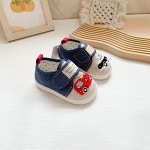 Close-up of baby walking shoes with cartoon car towel embroidery and denim texture