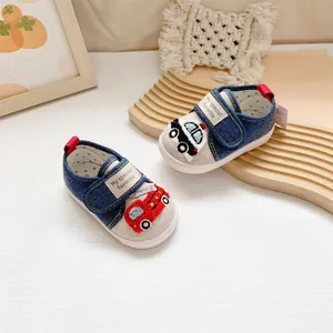 Close-up detail of baby walking shoes featuring cartoon car embroidery and soft denim fabric
