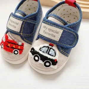 Close-up detail of toddler shoes featuring fire truck and police car towel embroidery