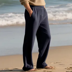 Men's casual dark blue ribbed wide-leg pants with drawstring waist in beach setting.