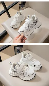 Detalle de zapatillas blancas de malla transpirable para niños con velcro y suela gruesa.