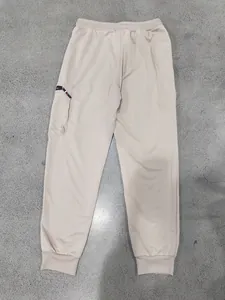 Detailed view of beige heavy cotton sweatpants featuring a cargo pocket and elastic cuffs