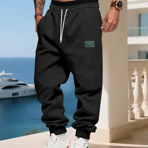 Mens black fleece joggers with white drawstrings in a casual outdoor setting