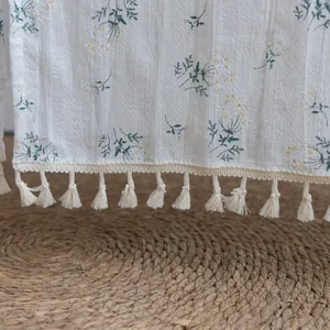 Close-up detail of cotton floral door curtain with elegant beige tassel accents