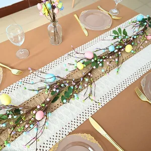 Detailed view of colorful Easter egg and berry garland on a dining table.