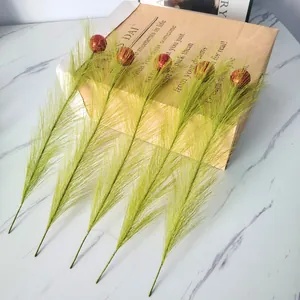 Detailansicht grüner künstlicher Weihnachtszweige mit glitzernden roten Schaumkugeln