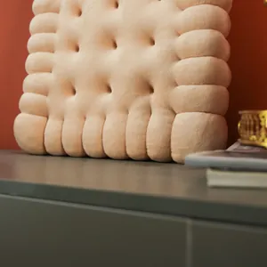 Close-up detail of the soft short plush texture of the biscuit-shaped cushion.