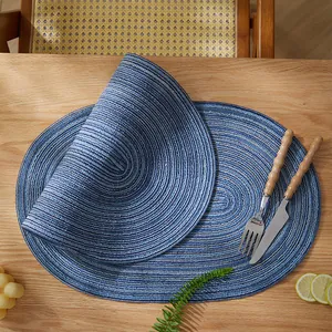 Detalle de manteles individuales ovalados azules con textura en espiral sobre madera