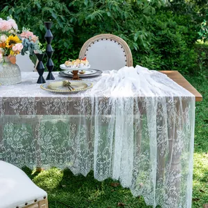 Elegant white lace table runner with floral embroidery in a garden setting