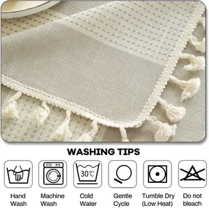 Détail de la texture d'une nappe en lin avec franges et conseils de lavage en anglais