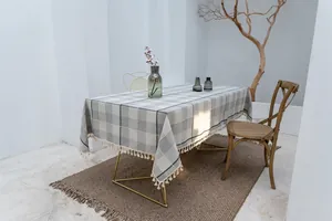 Elegante grau-karierte Tischdecke aus Baumwollleinen mit Quasten in einem minimalistischen Raum