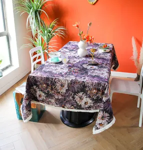 Detailed view of a premium purple floral tablecloth with elegant white fringe tassels.