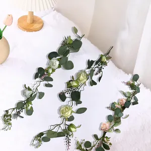 Detailed view of artificial rose and eucalyptus garlands on a soft white surface