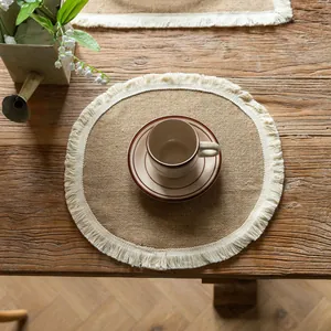Macro view of natural jute placemat with delicate cream fringe on a rustic wood tabletop