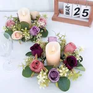 Detail of artificial eucalyptus and rose candle rings with warm LED candles