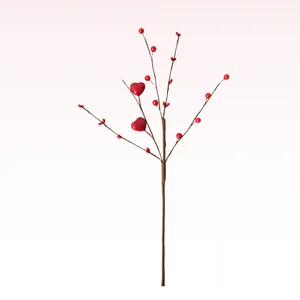 Close-up detail of artificial red berry branch featuring decorative heart ornaments