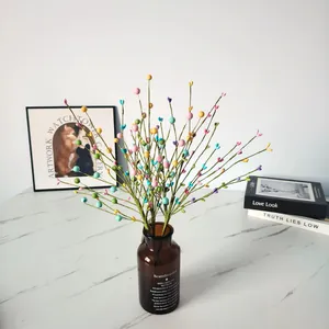 Macro view of colorful heart-shaped foam berry branches displayed in a vintage brown glass vase